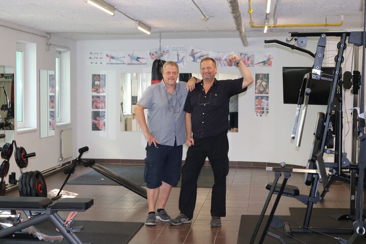 Peter und Gustl haben sichtlich Spaß bei der Hausführung und zeigen stolz Bizeps und Fitnessraum. (Bild: FSW)
