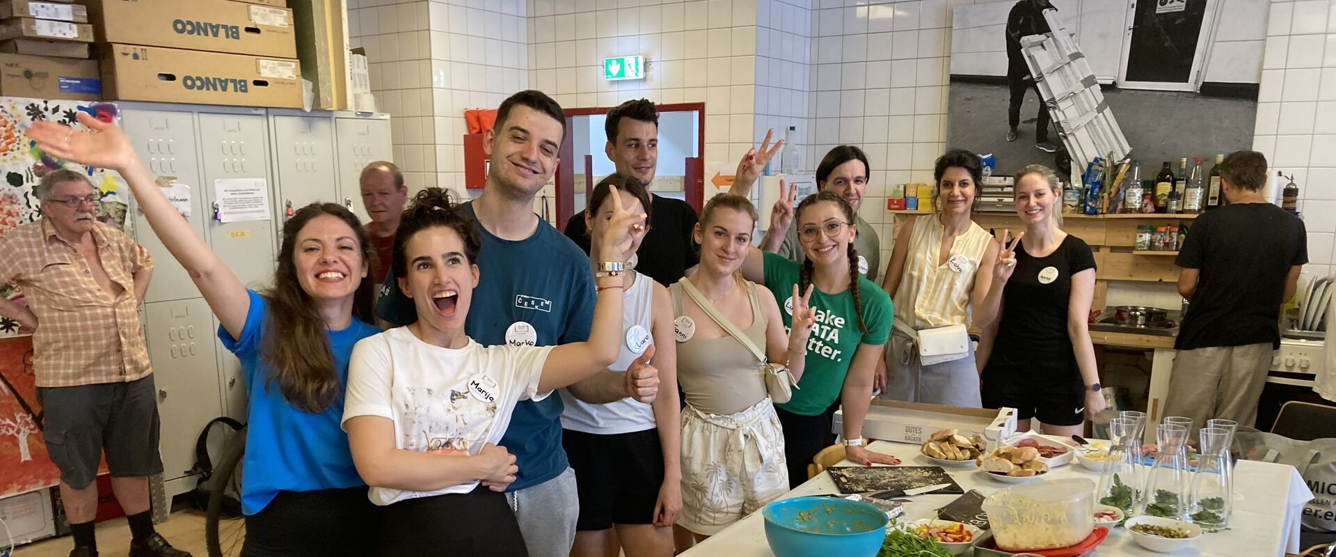 Teilnehmer:innen des Group Graduate Programme der Erste Group beim SAD+ bereiten das Buffet des Sommerfestes von Obdach Forum.