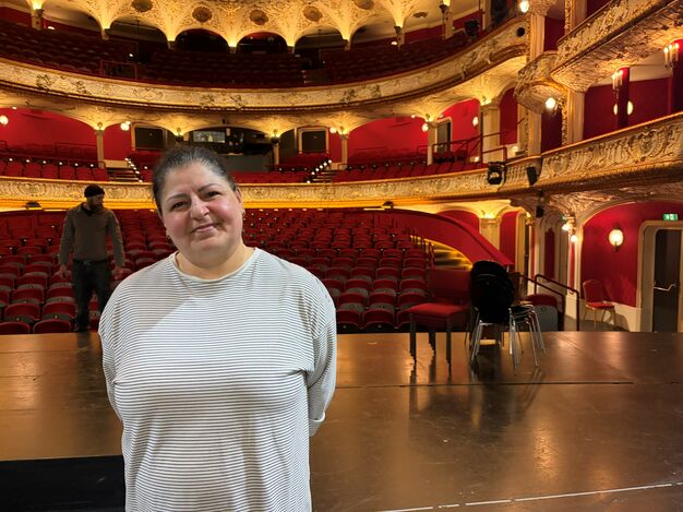 Sonia B. auf der Bühne des Wiener Volkstheaters. Im Hintergrund der erleuchtete Zuschauerraum. 