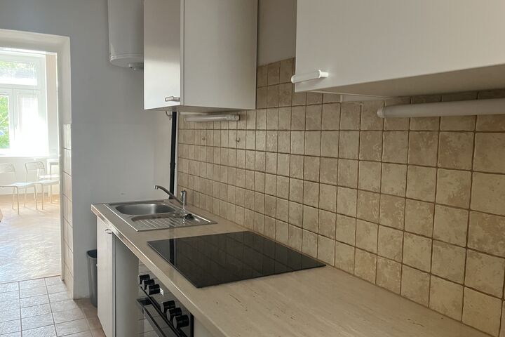 Die Küchen verfügen über einen Herd und einen Kühlschrank. (Bild: FSW) Eine Küchenfront mit Herd, Abwasch und Blick auf das Wohnzimmer.