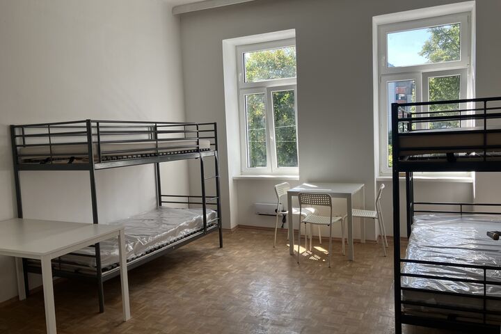 Obdach Dreyhausenstraße bietet sicheren Raum nach den Flucht. (Bild: FSW) Ein Zimmer mit zwei Etagenbetten, Tischen uns Sessel.