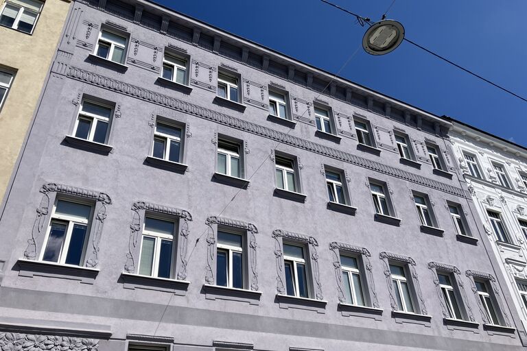 Ein Wiener Wohnhaus vor blauem Himmel.