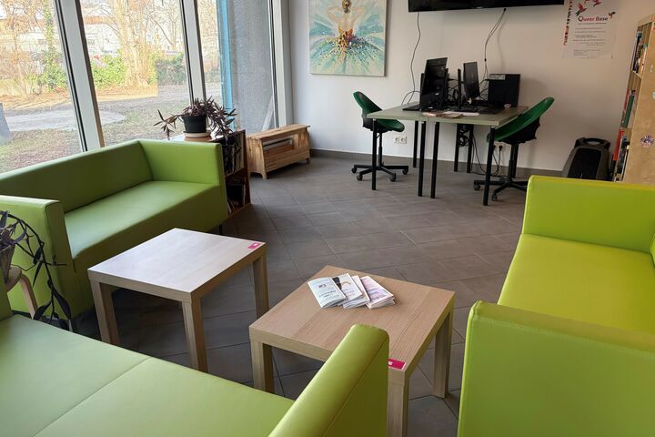 Eine hellgrüne Sitzlandschaft mit Tischen und zwei Computerplätze im Hintergrund. 